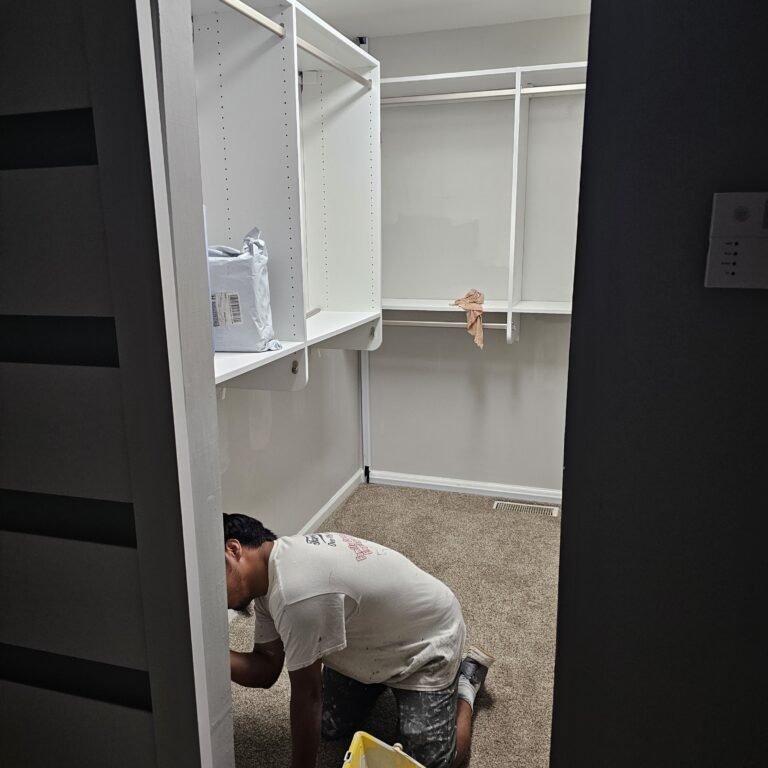 Painter working beside white interior trim during renovation