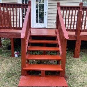 Red stained wooden deck with steps and railings